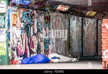 Sonno agitato in una Bristol sottopassaggio pedonale con graffiti, città di Bristol, Inghilterra, Regno Unito Foto Stock