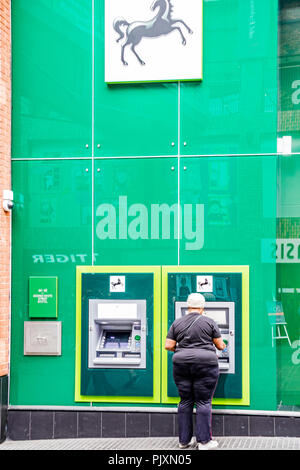Signora usando un Lloyds Bank bancomat, Bristol, Inghilterra, Regno Unito Foto Stock