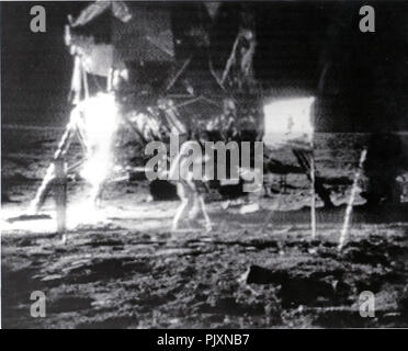 La luna - (file) -- astronauta Edwin E. "Buzz" Aldrin, Jr., passeggiate in fretta sulla superficie della Luna in quello che è stato descritto come un canguro eseguire, domenica 20 luglio, 1969. Astronauta Neil A. Armstrong è vicino al modulo lunare (LM). Credito: la NASA via CNP /MediaPunch Foto Stock