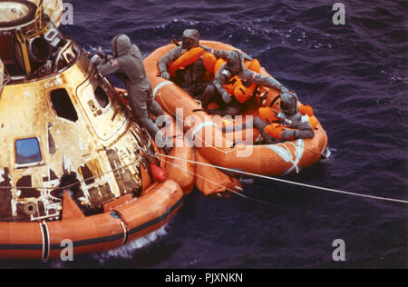 Oceano Pacifico - (file) -- Pararescueman tenente Clancy Hatleberg chiude l'Apollo 11 berlina veicolo spaziale come gli astronauti Neil Armstrong e Michael Collins e Buzz Aldrin, Jr., attendono di prelievo in elicottero dalla loro zattera di salvataggio. Essi spruzzato verso il basso a 12:50 pm EDT Luglio 24, 1969, 900 chilometri a sudovest di Hawaii dopo il successo di un atterraggio lunare di missione. Credito: la NASA via CNP /MediaPunch Foto Stock