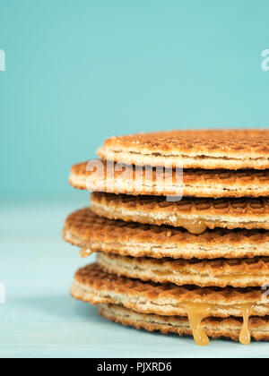 Stroopwafels o caramello Waffle olandese vicino sul turchese sullo sfondo di legno Foto Stock