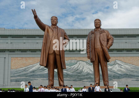 La Corea del Nord, la collina Mansudae Grand monumento, statue di Kim Il Sung e Kim Jong Il, con mosaico di Paekdu montagna dietro.con i turisti i visitatori Foto Stock