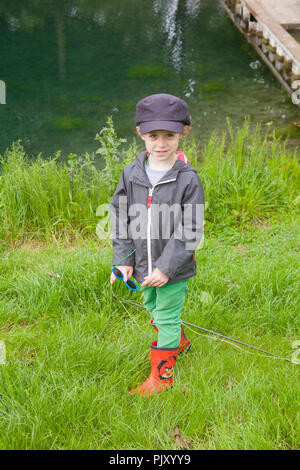 Ragazzo di quattro anni a Meon Springs Trout Fishery, East Meon, Hampshire, Inghilterra, Regno Unito. Foto Stock