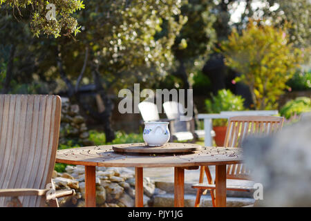 Bellissima ceramica decorata mug su una tavola di legno in outdoor cafe di mattina presto in Italia Foto Stock