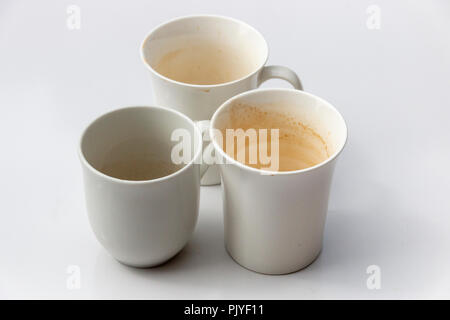 Una chiusura laterale di tre bianco sporco tazze da caffè in un gruppo su un isolato sfondo bianco Foto Stock