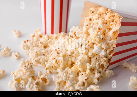 Il Popcorn in scatola di cartone con sfondo bianco. Composizione orizzontale. Vista in elevazione. Foto Stock