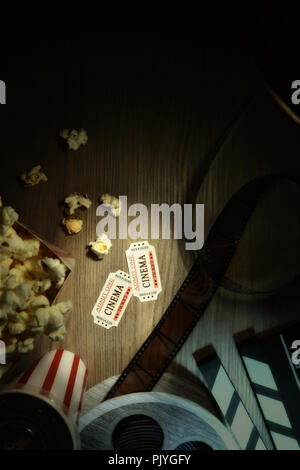 Vintage attrezzature e elementi di cinema su un tavolo di legno. Concetto di guardare film. Composizione verticale. Vista dall'alto. Foto Stock