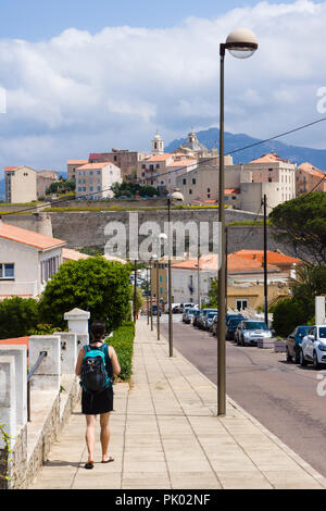 Turistico con zaino a piedi verso la cittadella di Calvi. Calvi, Corsica, Francia Foto Stock