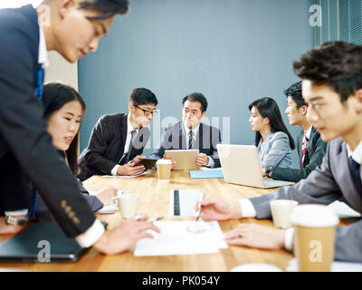 Asian corporate persone discutere di affari in gruppi. Foto Stock