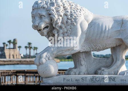 Il marmo bianco di Carrara lion statua su Sant Agostino, Florida's Bridge dei Lions su Matanzas Baia, con Castillo de San Marcos fort in background. (USA) Foto Stock