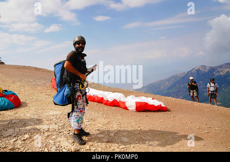 Fethiye, Mugla/Turchia- 19 Agosto 2018: parapendii preparazione di attrezzature su Babadag per il lancio / pronto a volare Foto Stock