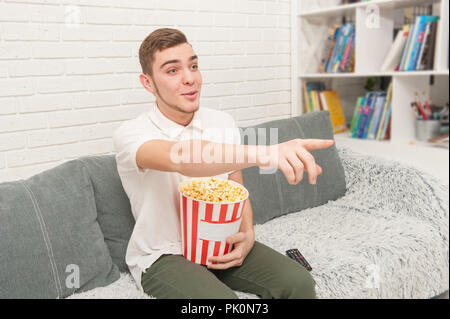 Un ragazzo adolescente mangiare popcorn Foto Stock