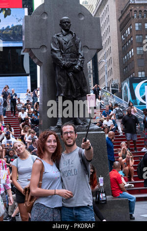 I turisti in tempi sSquare prendere un selfie davanti alla statua del Padre Patrick Duffy. Im Manhattan, New York City. Foto Stock