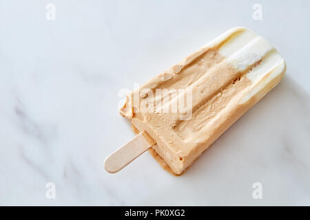 In casa rinfrescante caffè ghiacciato popsicles su un bastone contro un sfondo marmo con spazio di copia Foto Stock