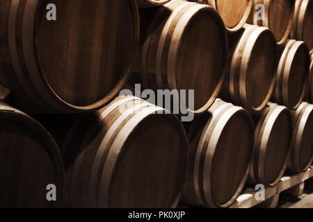 La produzione di vino. Round in botti di legno scuro in cantina, vicino la foto con il fuoco selettivo Foto Stock