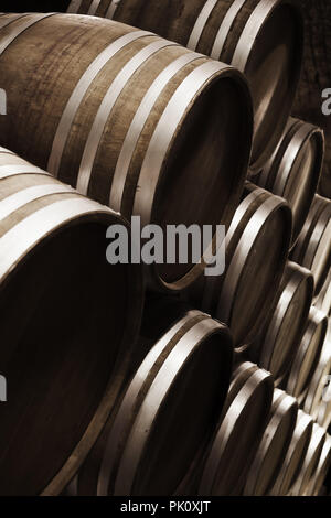 Il magazzinaggio dei vini. Round in botti di legno scuro in cantina, close-up foto verticale con il fuoco selettivo Foto Stock