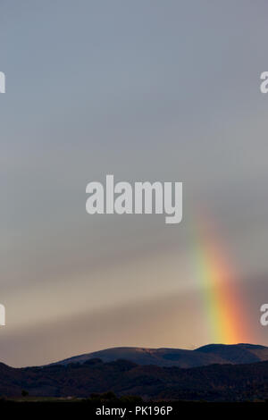 Bellissimo e surreale vista di parte di un arcobaleno su alcune colline Foto Stock