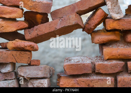 Foro nel vecchio muro in mattoni sbriciolare Foto Stock