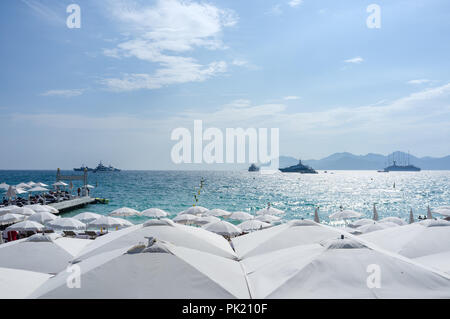 Yatchs e ombrelloni sulla spiaggia di Cannes, nel sud della Francia Foto Stock