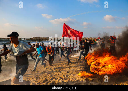 Settembre 10, 2018 - almeno 10 palestinesi su una flottiglia di decine di navi da guerra lanciato dalla città di Gaza sono stati feriti da marina israeliana spari dopo l'avvicinamento alla frontiera marittima fuori la costa di Gaza. Decine di dimostranti palestinesi sono stati anche feriti da arma da fuoco israeliano e gas lacrimogeni durante una dimostrazione sulla costa vicino a Gaza City. La manifestazione è stata organizzata dalla maggiore commissione nazionale del Grande marzo di ritorno e la rottura di Gaza assedio, che ha tentato di rompere le undici anni-lungo il blocco dell'enclave palestinese. La flottiglia partì il porto di Gaza City voce t Foto Stock