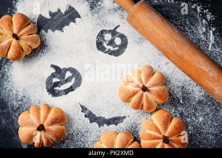 Torte fatte in casa a forma di zucca di Halloween e decorazioni su tavola. I dolci di Halloween, vista dall'alto Foto Stock