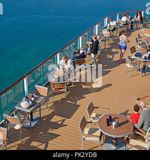 Guardando verso il basso a partire da sopra alla nave da crociera deck liner & gruppo di persone ai tavoli godendo di un caldo sole all'aperto prima colazione Adriatic summer tour vacanza Foto Stock