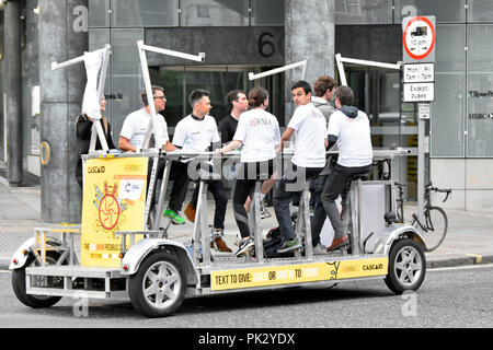 Chuggers o carità rapinatori gruppo di giovani asset management persone su Pedibus al pedale lungo la City of London street per raccogliere fondi per beneficenza Cascaid Foto Stock