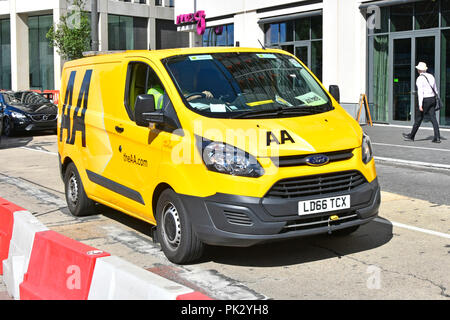 Ford Transit van & driver con AA logo sulla ripartizione giallo van guidato lungo il centro città in opere stradali Newham Stratford East London Inghilterra England Regno Unito Foto Stock