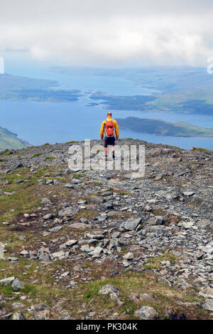 Walker scendendo ben più a Mull con vedute di Loch Na Keal con l'isola di Eorsa e al di là del si restringe tra Ulva sulla sinistra e Mull Foto Stock