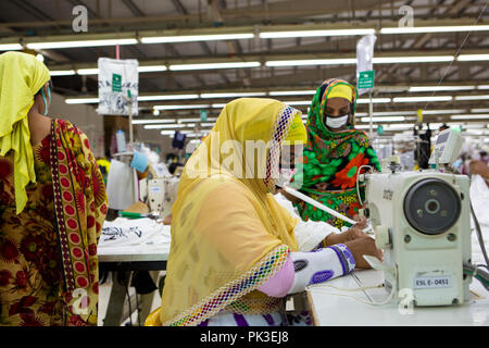 Una donna che lavora su una macchina da cucire ad una fabbrica di indumento a Dhaka, nel Bangladesh. Foto Stock