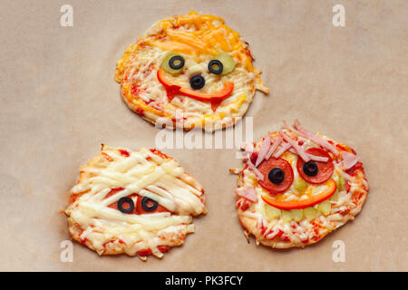 La pizza di Halloween con mostri, al di sopra della scena con decor e su una carta craft casella Sfondo, idea per la casa parte cibo, facile, sano e delizioso cibo divertente Foto Stock