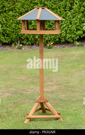 Stand alone bird feeder di legno con un coperchio superiore di plastica Foto Stock