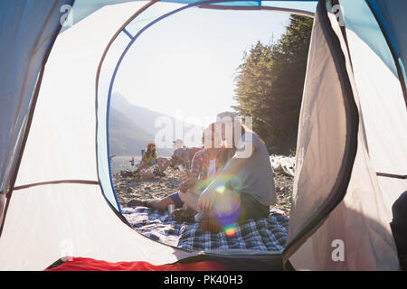 Giovane rilassante vicino alla tenda in campagna Foto Stock