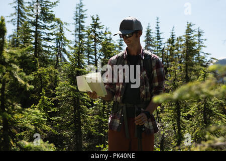 Uomo che guarda la mappa in campagna Foto Stock