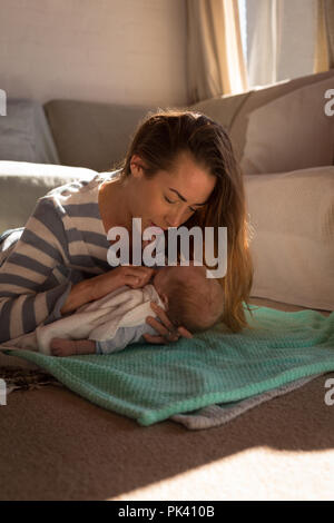 La madre gioca con il suo bambino sul pavimento Foto Stock