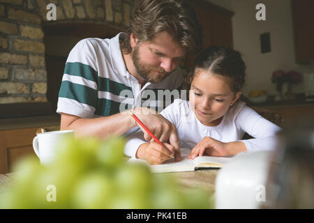 Padre aiutando la figlia negli studi Foto Stock