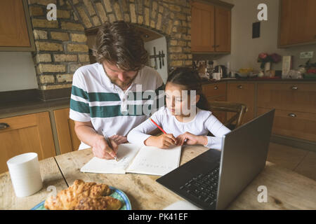 Padre aiutando la figlia negli studi Foto Stock