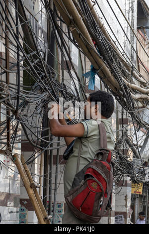 Il tecnico che fissa le linee di alimentazione nella Vecchia Delhi, New Delhi, Delhi, India Foto Stock