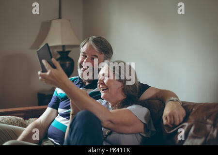 Coppia senior tenendo selfie su telefono cellulare a casa Foto Stock