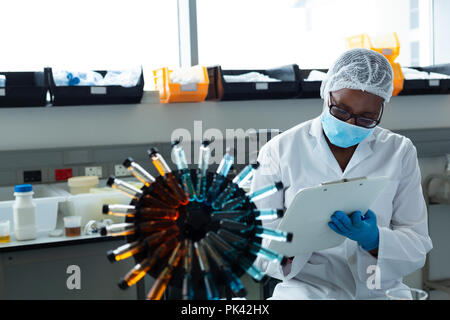 Donna scienziato iscritto negli appunti Foto Stock