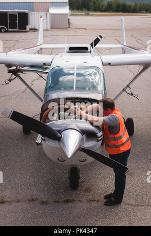 Ingegnere di manutenzione motore degli aerei nei pressi di hangar Foto Stock