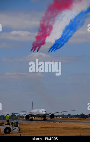 United Airlines Boeing 777-300ER taxi sotto la RAF frecce rosse a Londra Heathrow durante la RAF 100 Foto Stock