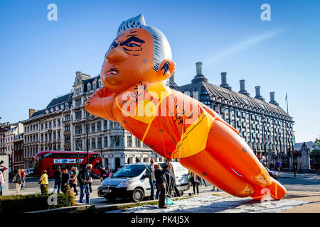 Manifestanti volare un 29ft lungo il dirigibile Bikini-Clad del sindaco di Londra Sadiq Khan oltre la piazza del Parlamento, London, Regno Unito Foto Stock