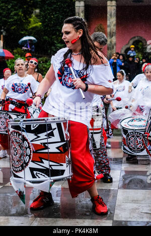 Batala Bangor al Festival n. 6 di sabato 8 settembre 2018 tenutasi a Portmeirion, Gwynedd, il Galles del Nord. Batala Bangor Drum Corp giocare sotto la pioggia battente nella centrale Piazza. Foto di Julie Edwards. Foto Stock