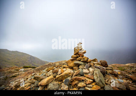 Le splendide vedute guardando fuori attraverso la campagna del Welsh come ho salito Mount Snowdon. La Moody nuvole aggiunto al suggestivo paesaggio. Foto Stock