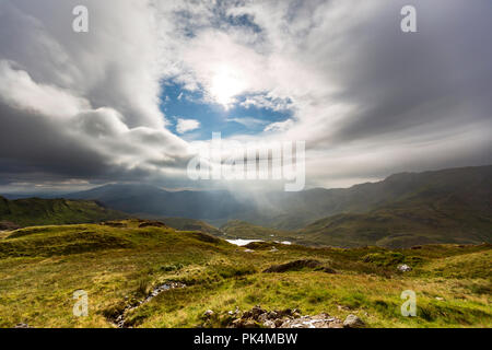 Le splendide vedute guardando fuori attraverso la campagna del Welsh come ho salito Mount Snowdon. La Moody nuvole aggiunto al suggestivo paesaggio. Foto Stock