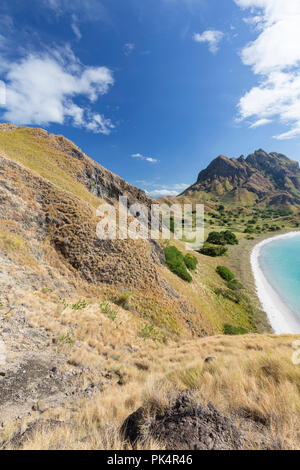 Visualizzazione verticale di un vuoto di spiaggia bianca e le montagne a Pulau Padar isola nel Parco Nazionale di Komodo. Foto Stock