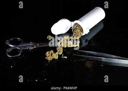Pinzette forbici e la prescrizione di marijuana isolata su uno sfondo nero. Foto Stock