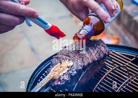 La cottura di una marinata di bimbo indietro nervature su un barbecue per esterni Foto Stock