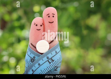 Dita arte della coppia felice. Il concetto di un uomo e di una donna sulla pillola per la perdita di peso. Foto Stock